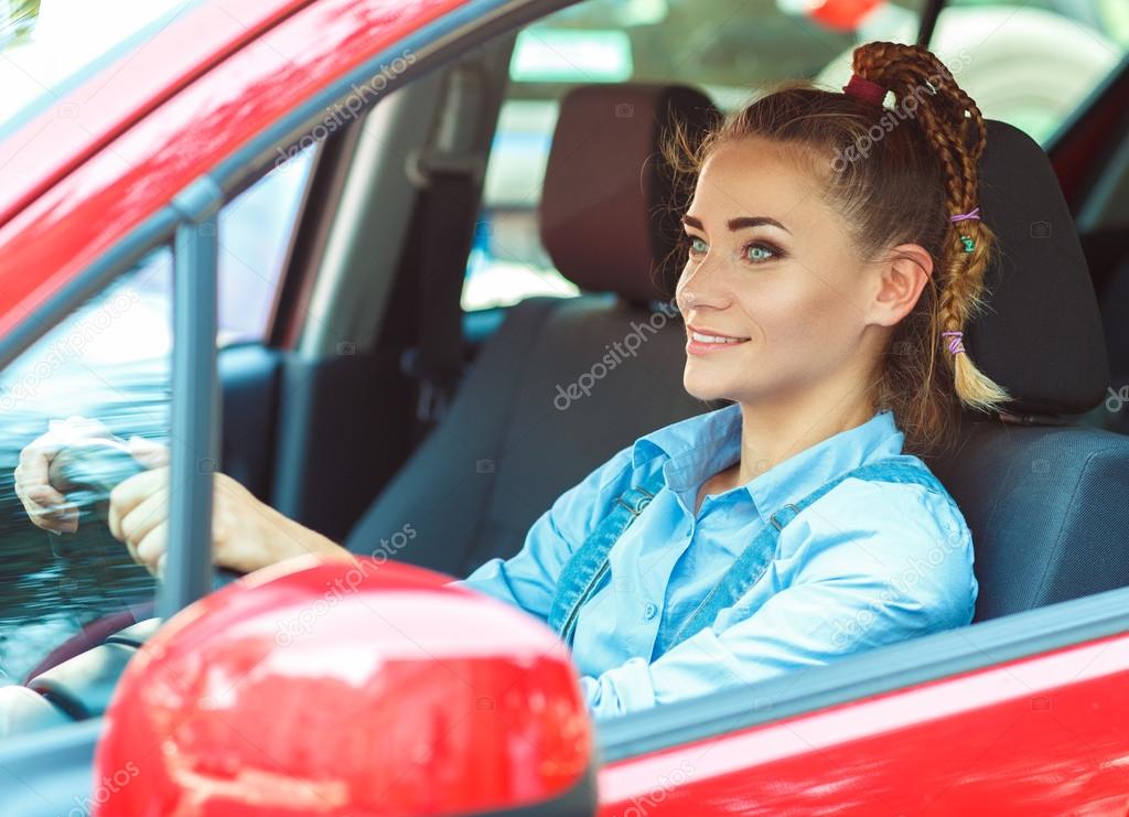 Young smiling woman driving the car