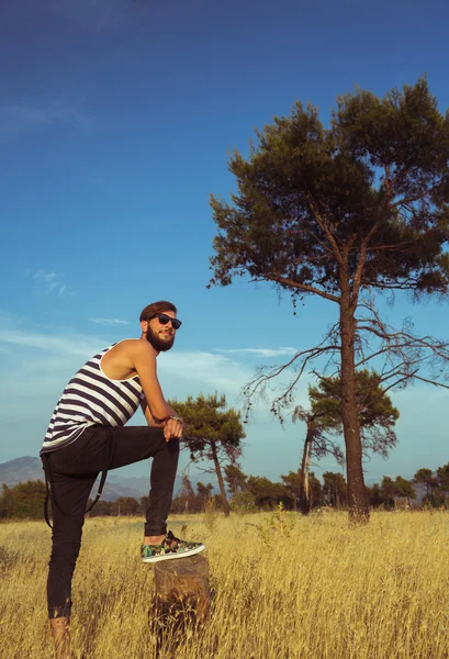 Portret van een jonge stijlvolle knappe man in de savanne — Stockfoto