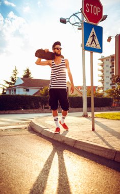 C bir sokakta bir kaykay ile güneş gözlüğü şık adam