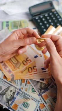 Erkek eli, BTC bitcoin 'i farklı para birimlerinin banknotları olan dolar ve avrolar ile karşılaştırır ve döndürür. Kripto para birimi kavramı ve engelleme teknolojisinin geniş dünyası..