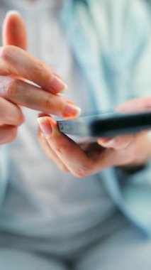 Sosyal medyada akıllı telefondan yayın yapan, dokunmatik ekranlara dokunan, kurye uygulaması kullanan bir kadın. Elinde cep telefonu olan bir kadın. Dikey video