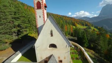 St. Jacob Kilisesi 'nin havadan görünüşü, arka planda Ortisei kasabasının yanındaki San Giacomo Kilisesi Langkofel grubunun dağları FPV insansız hava aracı ile filme alındı. Bolzano ili