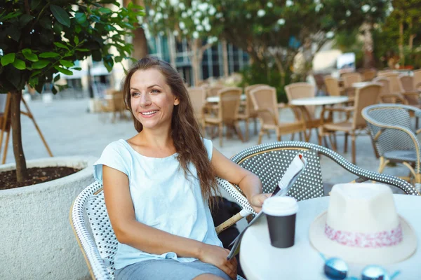 Femme relaxante dans le café en plein air - boire du café et lire — Photo