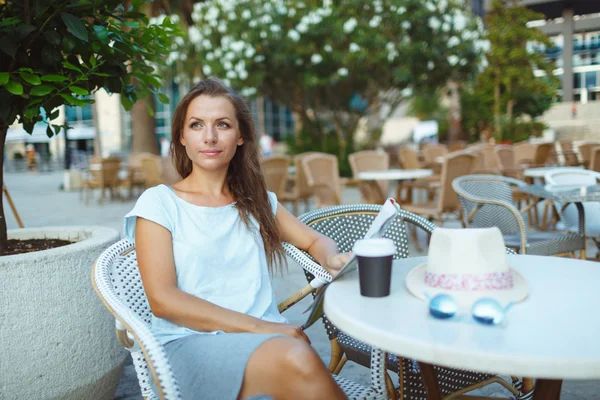Femme relaxante dans le café en plein air - boire du café et lire — Photo
