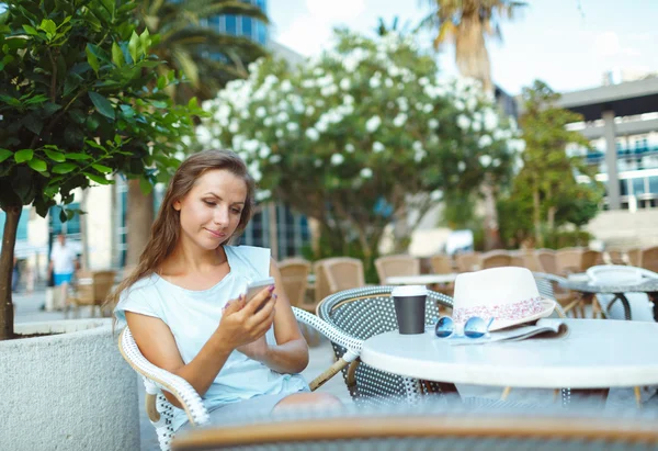 Mulher relaxante no café ao ar livre - beber café e usando um — Fotografia de Stock