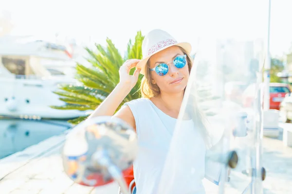 Happy young woman drinking takeaway coffee near her red moped in — 스톡 사진