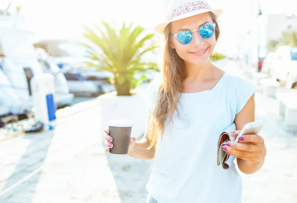 Happy young woman drinking takeaway coffee and walking on the wa — 스톡 사진