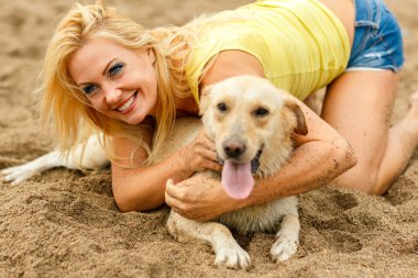 Plajda oynayan köpek kadınla