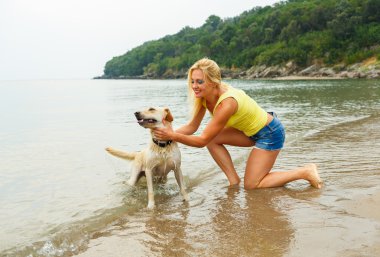 Plajda oynayan köpek kadınla