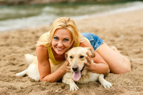 Mulher com cão brincando na praia — Fotografia de Stock