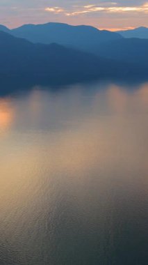 Akşamları Vancouver 'ın kuzeyindeki deniz manzarası. Mavi bulutlu gökyüzü ve dağların siluetleri. British Columbia, Kanada.