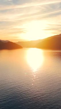 Vancouver 'ın kuzeyindeki güzel günbatımında deniz manzarası. Howe 'daki fiyortlar. Dağların siluetlerinin üzerine güneş batıyor. British Columbia, Kanada.