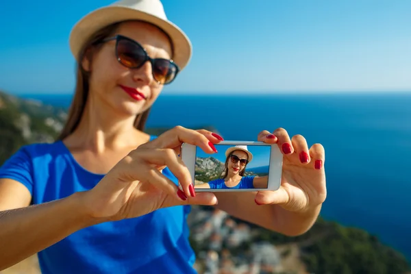 Lány a kalapban, selfie azáltal, hogy a smartphone-ra a háttérképet — Stock Fotó