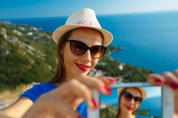 Menina no chapéu fazendo selfie pelo smartphone no backgroun — Fotografia de Stock