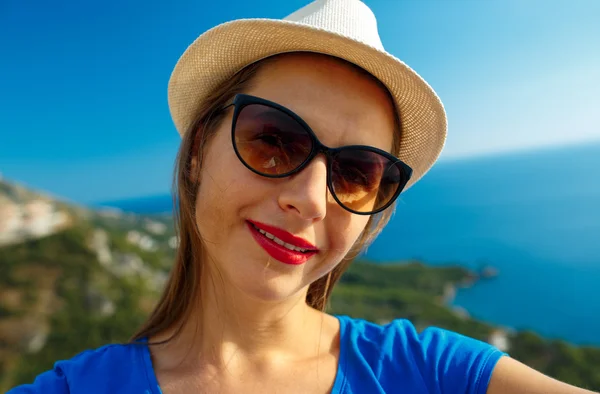 Chica en el sombrero haciendo selfie por el teléfono inteligente en el backgroun —  Fotos de Stock