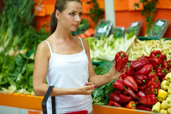 Young woman shopping in a supermarket in the department of fruit — 图库照片