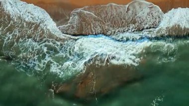 Güzel sahil ve denizin yukarıdan görünen manzarası. Dalgalar kumlu sahilde yuvarlanıyor. Kumda dalgalar, rahatlatıcı bir tatil fotoğrafı. Deniz ve karanın buluşma yeri. Korfu, Yunanistan.