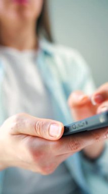 Sosyal medyada akıllı telefondan yayın yapan, dokunmatik ekranlara dokunan, kurye uygulaması kullanan bir kadın. Elinde cep telefonu olan bir kadın. Dikey video