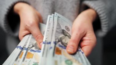 Amerikan Doları 'nı sayan bir kadın, yakın plan. Yatırım, başarı, finansal beklentiler veya kariyer gelişimi kavramı. Finansal okuryazarlık ve planlama. Yavaş çekim