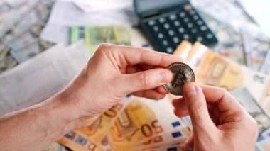 Erkek eli, farklı para birimlerinin -dolar ve avro- arka planında gümüş ve altın BTC bitcoin gösteriyor. Kripto para birimi kavramı ve engin blok zinciri dünyası.
