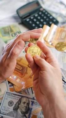 Erkek eli, BTC bitcoin 'i farklı para birimlerinin banknotları olan dolar ve avrolar ile karşılaştırır ve döndürür. Kripto para birimi kavramı ve engelleme teknolojisinin geniş dünyası..