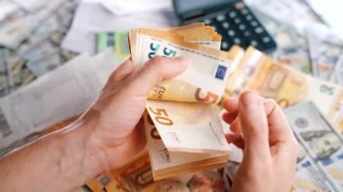 Ev muhasebesi konsepti. Adam para hesaplıyor, aylık konut giderleri, vergiler ve kredi kartı faturaları. Yavaş çekim