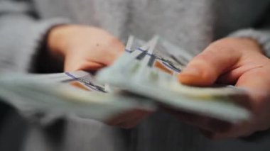 Amerikan Doları 'nı sayan bir kadın, yakın plan. Yatırım, başarı, finansal beklentiler veya kariyer gelişimi kavramı. Mali okuryazarlık ve planlama