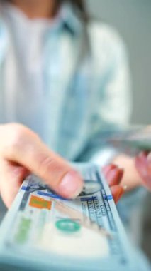 Amerikan Doları 'nı sayan bir kadın, yakın plan. Yatırım, başarı, finansal beklentiler veya kariyer gelişimi kavramı. Finansal okuryazarlık ve planlama. Dikey video