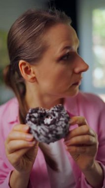 Yeme bozukluğu. Çörek yiyen bir kadın kimsenin izlemediğinden emin olmak için etrafa bakıyor. Şeker bağımlılığı... Ağır çekim. Dikey