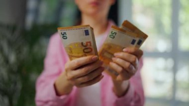 Avro banknotlarını sayan bir kadın, yakın plan. Yatırım, başarı, finansal beklentiler veya kariyer gelişimi kavramı. Mali okuryazarlık ve planlama