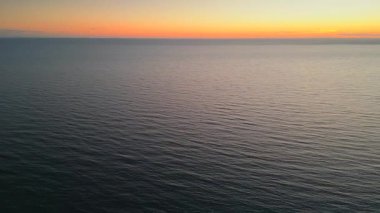 Deniz ya da okyanus üzerinde gün batımının hava manzarası. Sinema robotu hava görüntüsü güzel bir akşam güneşi denizin üstünde. Doğa güzelliği.