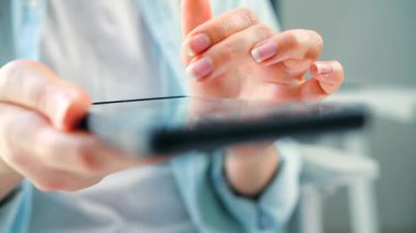 Kurye uygulaması kullanarak akıllı telefondan sosyal medya kaynaklarını tarayan bir kadın. Cep telefonu tutan kadın..