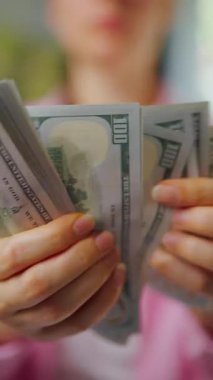 Amerikan Doları 'nı sayan bir kadın, yakın plan. Yatırım, başarı, finansal beklentiler veya kariyer gelişimi kavramı. Finansal okuryazarlık ve planlama. Dikey