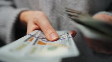 Amerikan Doları 'nı sayan bir kadın, yakın plan. Yatırım, başarı, finansal beklentiler veya kariyer gelişimi kavramı. Finansal okuryazarlık ve planlama. Yavaş çekim