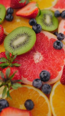 Meyveli taze meyve dilimlerinin arka planı. Dönüşümlü yaz meyve parçaları. Diyet, diyet, sağlıklı vejetaryen yemekleri. Vejetaryen tatlı yiyecekler, düz uzanma. Dikey