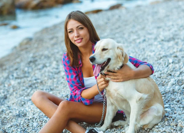 Mulher com um cão em um passeio na praia — Fotografia de Stock