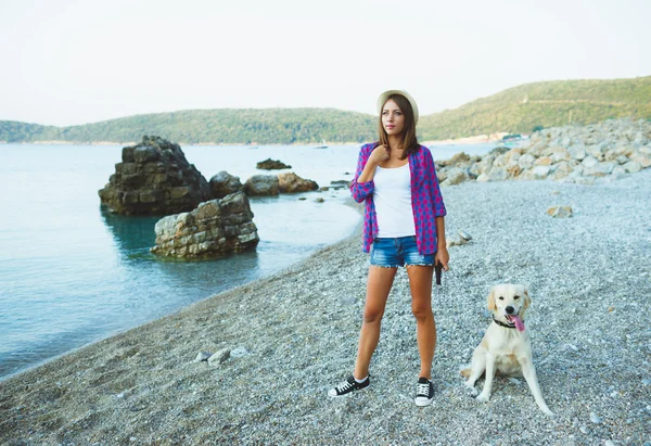 Kvinna med en hund på en promenad på stranden — Stockfoto