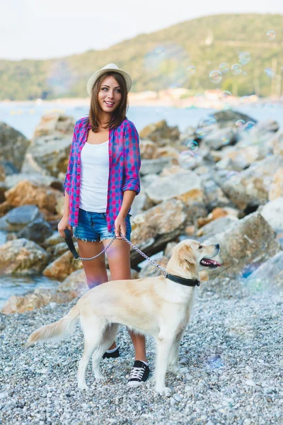 Woman with a dog on a walk on the beach