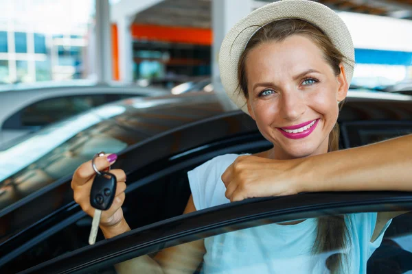 Счастливая женщина, стоящая рядом с машиной с ключами в руках - понятие "б" — стоковое фото
