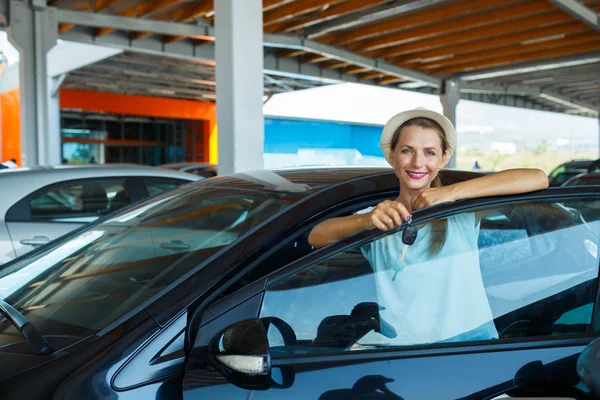 Mujer feliz de pie cerca de un coche con llaves en la mano - concepto de b —  Fotos de Stock