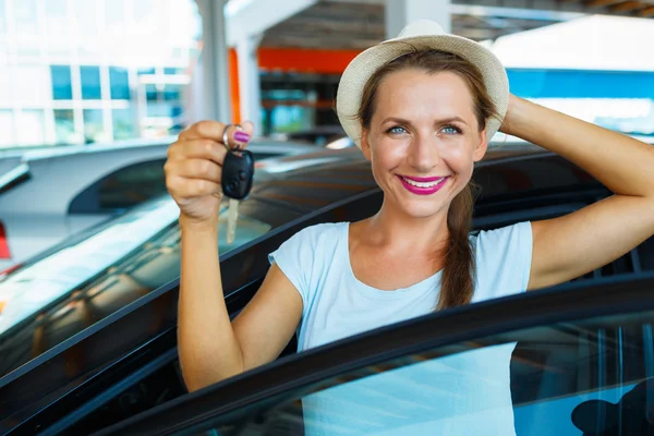Donna felice in piedi vicino a una macchina con le chiavi in mano - concetto di b — Foto Stock