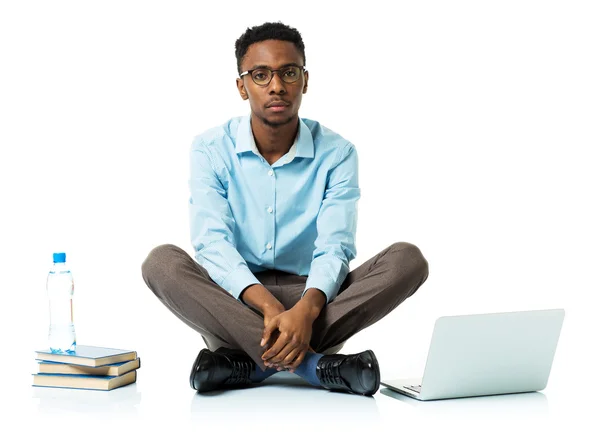Vakava afrikkalainen amerikkalainen college opiskelija laptop, kirjat ja — kuvapankkivalokuva