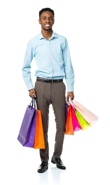 Homem americano africano feliz segurando sacos de compras no backgr branco — Fotografia de Stock