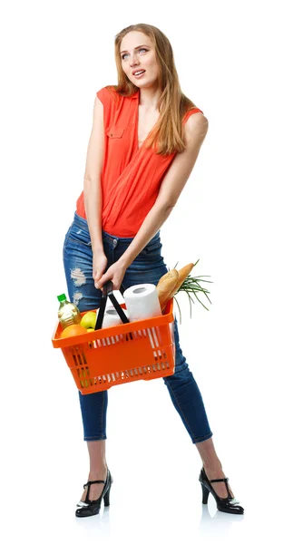 Mujer joven feliz sosteniendo una cesta llena de comida saludable en blanco —  Fotos de Stock