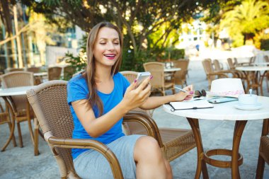 Bir not içinde smartphone ve geçici notlar kullanan genç güzel kadın
