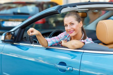 Bir Cabrio araba anahtarları elinde oturan genç kadın