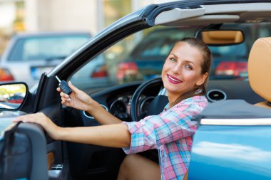 Bir Cabrio araba anahtarları elinde oturan genç kadın