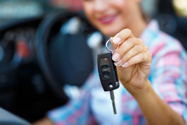 Woman standing near a convertible with keys in hand - concept of