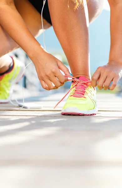 Взуття для бігу - жінка, що зв'язує взуття мереживами. Крупним планом жіночий спорт — стокове фото