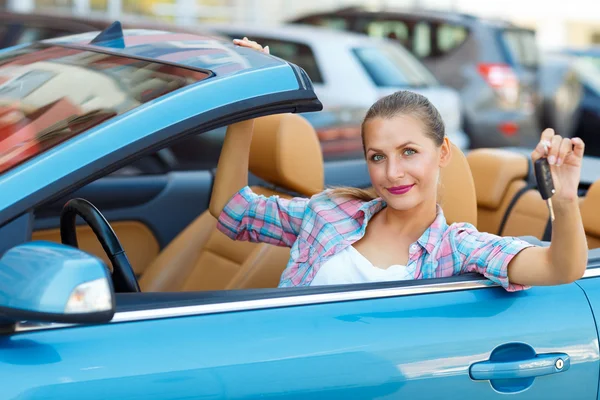 Bir Cabrio araba anahtarları elinde oturan genç kadın